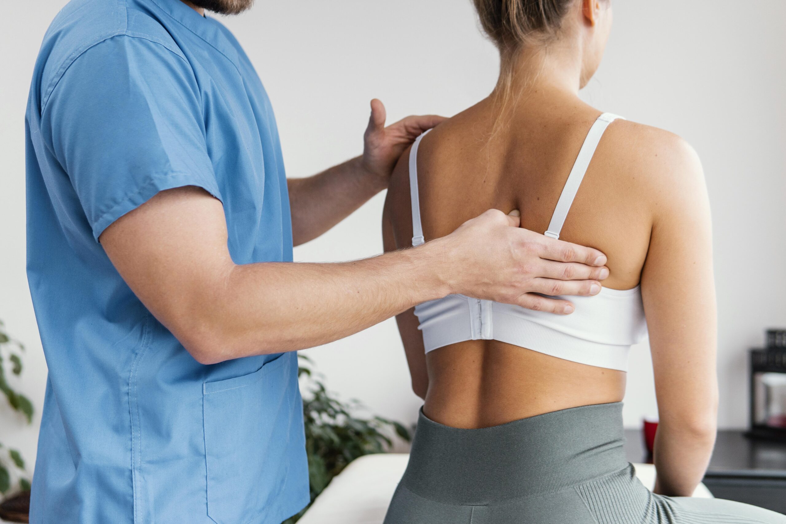 vista-laterale-del-terapista-osteopatico-maschio-che-controlla-l-osso-della-scapola-del-paziente-femminile